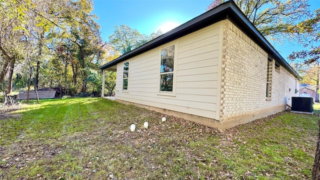 view of side of property featuring a yard and cooling unit