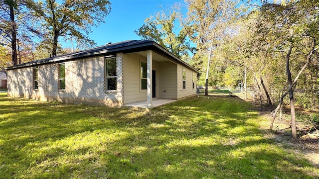 view of property exterior with a yard and a patio