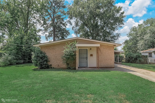 ranch-style home featuring a carport and a front yard