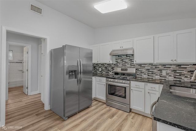 kitchen with light wood-type flooring, stainless steel appliances, vaulted ceiling, sink, and white cabinets