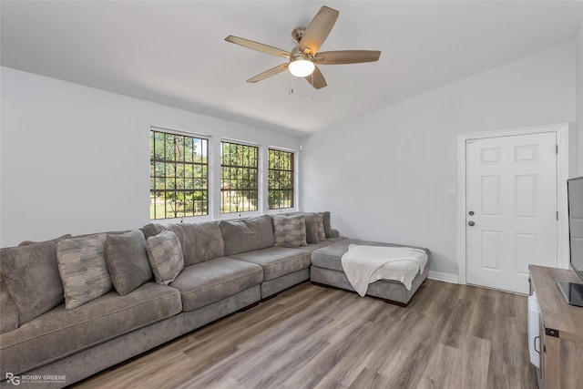 living room with ceiling fan, lofted ceiling, and light wood-type flooring