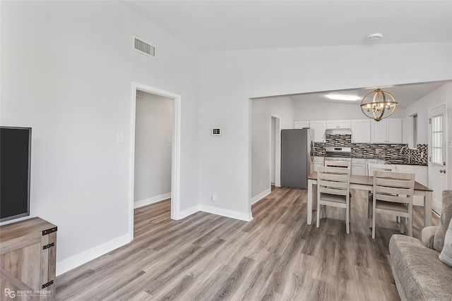 interior space featuring sink, light hardwood / wood-style floors, and an inviting chandelier