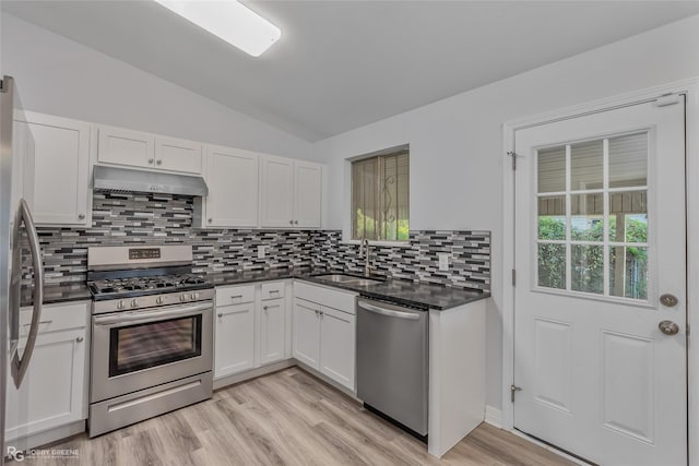 kitchen featuring white cabinetry, sink, stainless steel appliances, light hardwood / wood-style floors, and vaulted ceiling