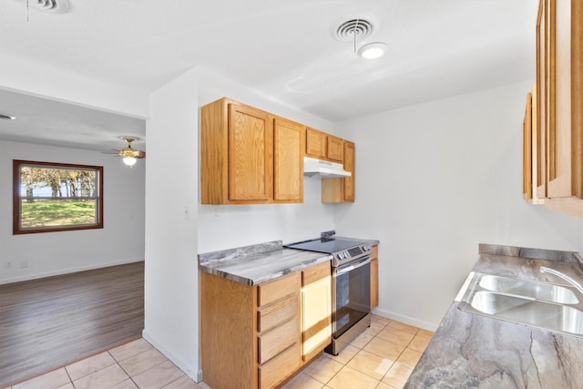 kitchen with ceiling fan, light tile patterned floors, sink, and electric range