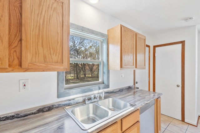 kitchen featuring light brown cabinetry, sink, stainless steel dishwasher, and light tile patterned flooring