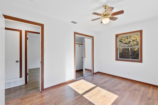 unfurnished bedroom featuring ceiling fan, light wood-type flooring, and a closet