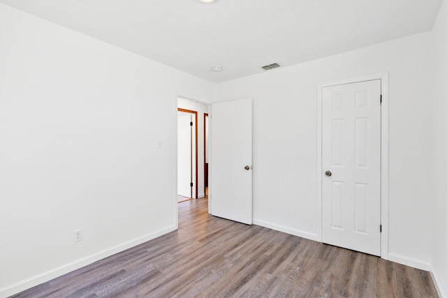 unfurnished bedroom with hardwood / wood-style flooring