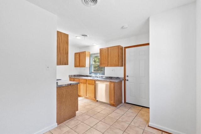 kitchen with sink, dishwasher, and light tile patterned flooring