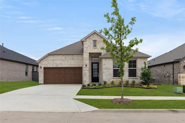 7212 Dragonfly Ln, Little Elm, TX 76227 - french country inspired facade with a garage, driveway, a front lawn, and brick siding