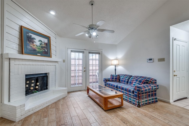 living room featuring vaulted ceiling, a textured ceiling, and hardwood / wood-style flooring