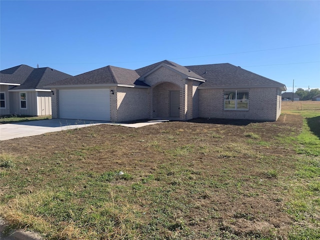 ranch-style house featuring a garage and a front lawn