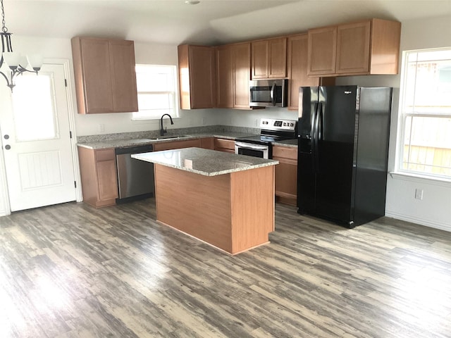 kitchen featuring a center island, sink, stainless steel appliances, and dark wood-type flooring