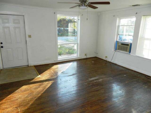 empty room featuring plenty of natural light, cooling unit, and dark wood-type flooring