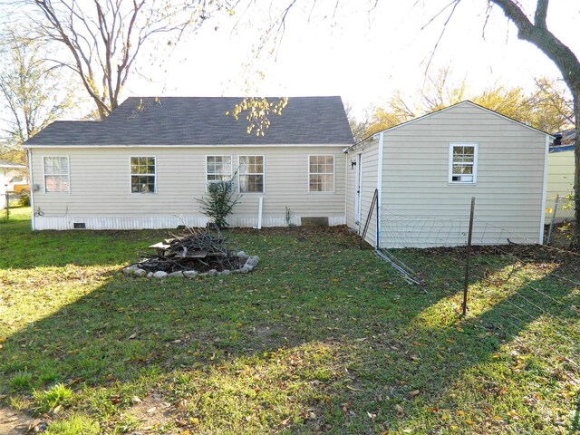 back of property featuring a lawn and a fire pit