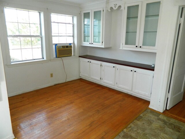 interior space featuring wood-type flooring, cooling unit, and crown molding