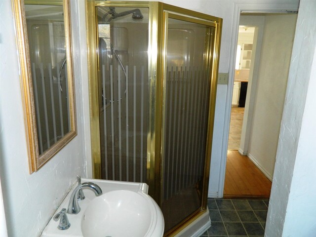 bathroom featuring tile patterned floors, sink, and a shower with door