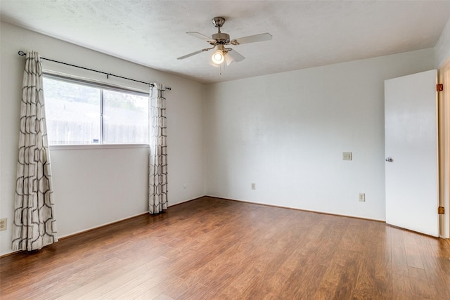 empty room with ceiling fan and wood-type flooring