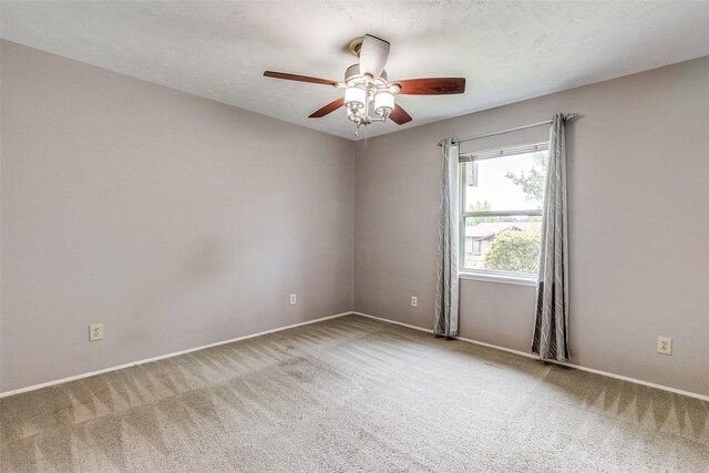 carpeted empty room with a textured ceiling and ceiling fan