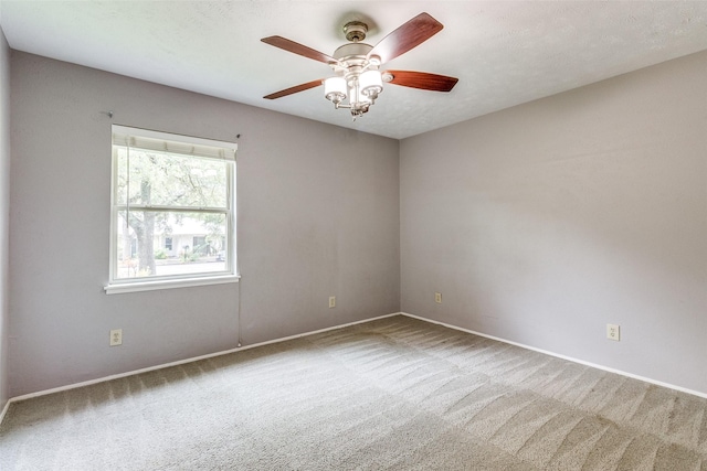 empty room with carpet flooring, ceiling fan, and a textured ceiling