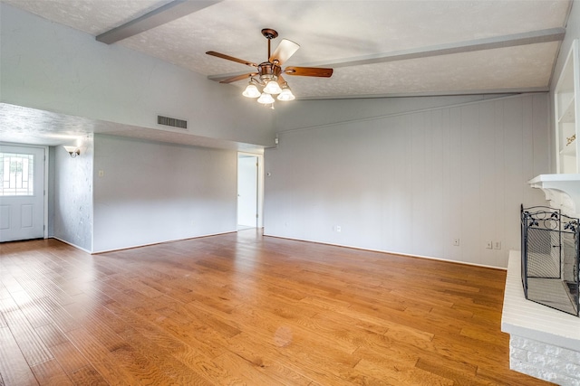 unfurnished living room featuring vaulted ceiling with beams, a textured ceiling, light hardwood / wood-style floors, and ceiling fan