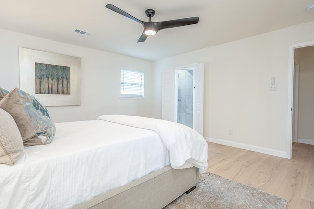 bedroom featuring ceiling fan, ensuite bathroom, and light wood-type flooring