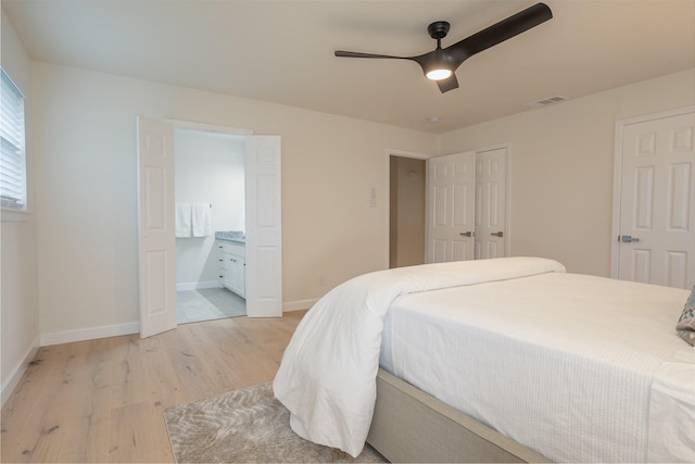 bedroom with connected bathroom, ceiling fan, and light hardwood / wood-style flooring