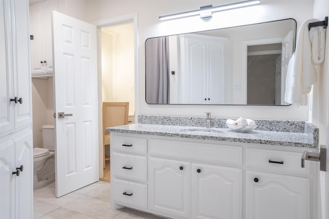 bathroom featuring tile patterned flooring, vanity, and toilet