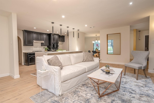 living room featuring a chandelier and light hardwood / wood-style floors