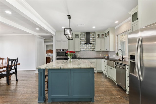 kitchen featuring dark stone counters, sink, decorative light fixtures, a kitchen island, and stainless steel appliances