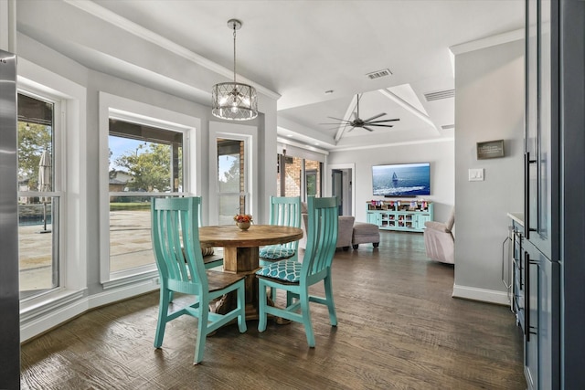 dining room with ornamental molding, ceiling fan with notable chandelier, and dark wood-type flooring