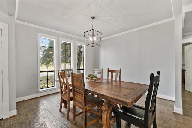 dining room with a healthy amount of sunlight, ornamental molding, dark wood-type flooring, and an inviting chandelier