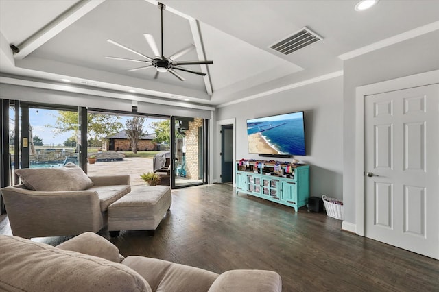 living room with ceiling fan, a raised ceiling, and dark wood-type flooring