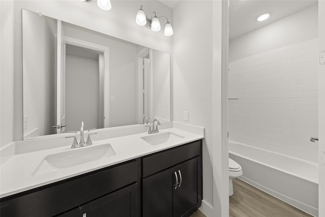 full bathroom with vanity, wood-type flooring, bathing tub / shower combination, and toilet