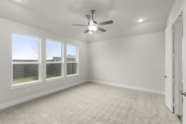 spare room with light colored carpet and ceiling fan