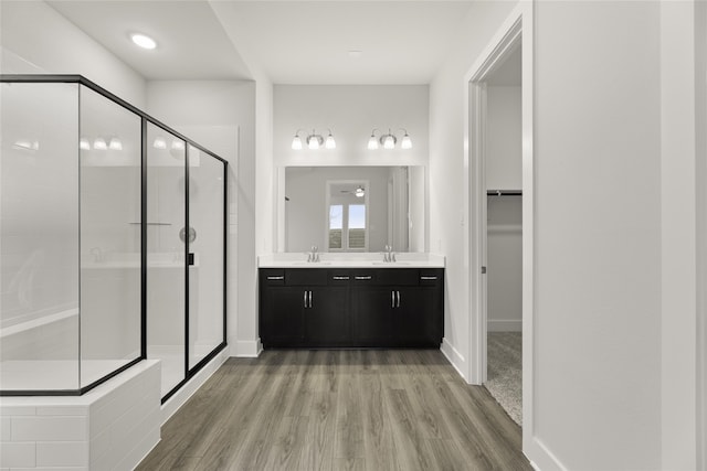 bathroom featuring vanity, a shower with shower door, and wood-type flooring