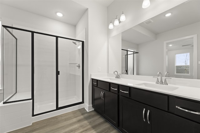 bathroom featuring wood-type flooring, a shower with shower door, and vanity