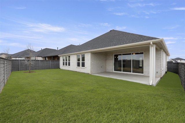 rear view of house with a yard and a patio