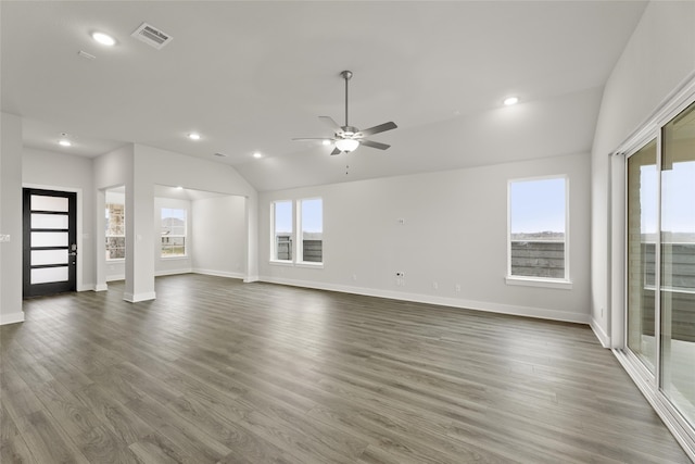 unfurnished living room with a healthy amount of sunlight, lofted ceiling, and dark hardwood / wood-style flooring