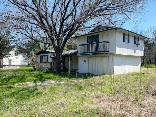 rear view of house featuring cooling unit and a balcony