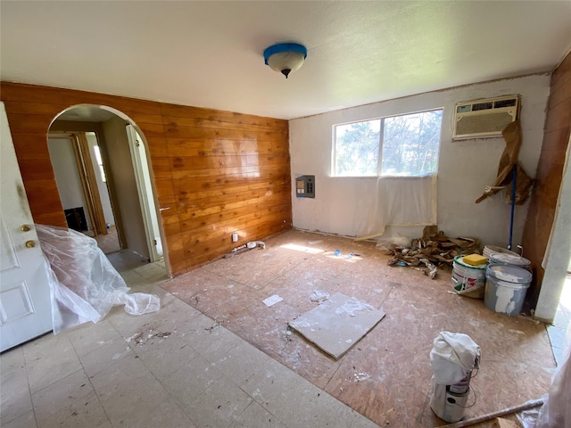 unfurnished room with a wall mounted AC and wooden walls