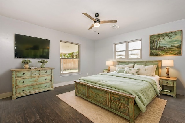 bedroom with multiple windows, ceiling fan, and dark hardwood / wood-style flooring