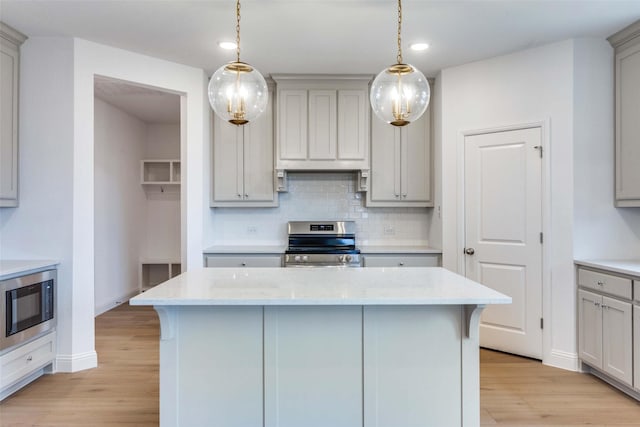 kitchen featuring black microwave, gray cabinetry, backsplash, and stainless steel electric range