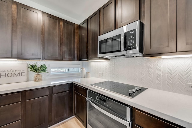 kitchen featuring appliances with stainless steel finishes, dark brown cabinetry, and backsplash