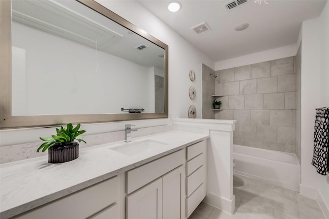 full bathroom with vanity, tiled shower / bath combo, tile patterned floors, and toilet