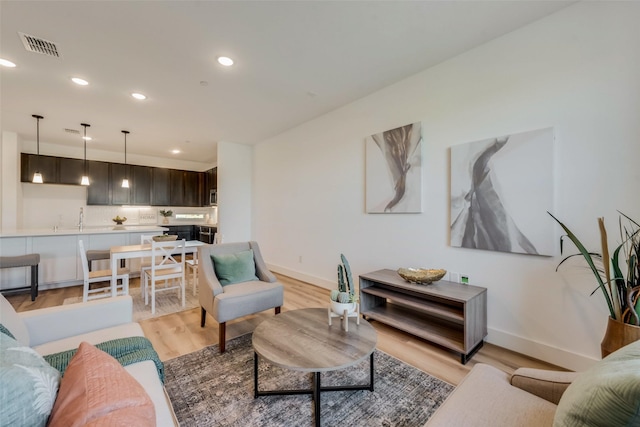 living room with sink and light hardwood / wood-style flooring