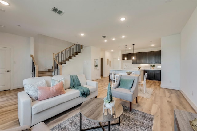 living room with light hardwood / wood-style floors and sink