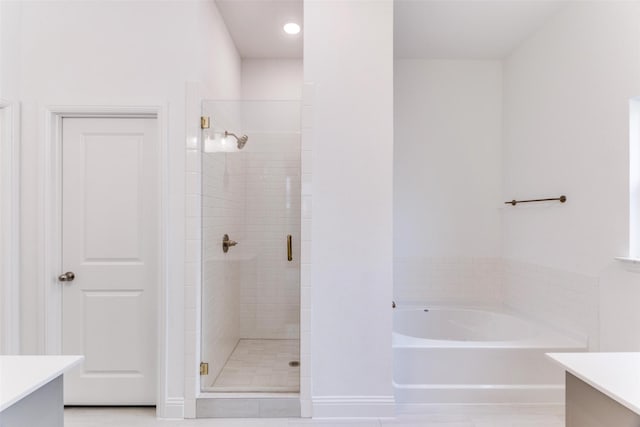 bathroom with a stall shower, a bath, and vanity