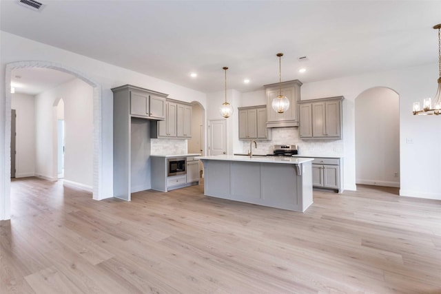 kitchen featuring stainless steel electric stove, black microwave, light countertops, and decorative light fixtures