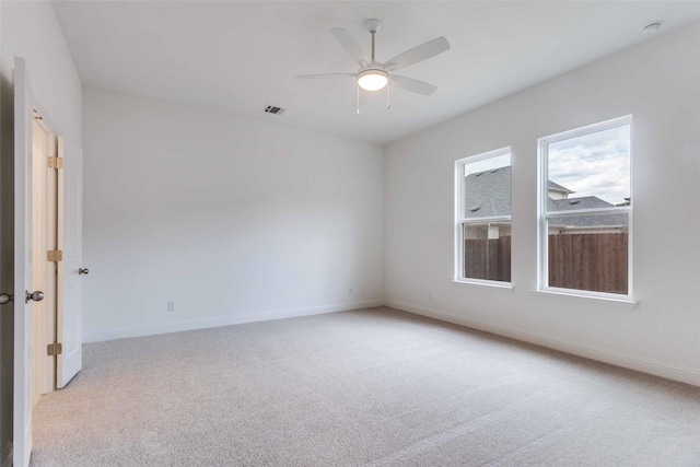 unfurnished room featuring visible vents, baseboards, a ceiling fan, and light colored carpet