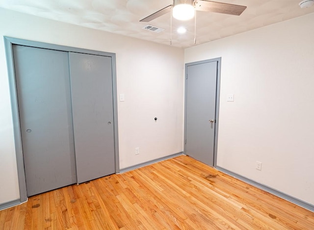 unfurnished bedroom featuring a closet, light hardwood / wood-style flooring, and ceiling fan